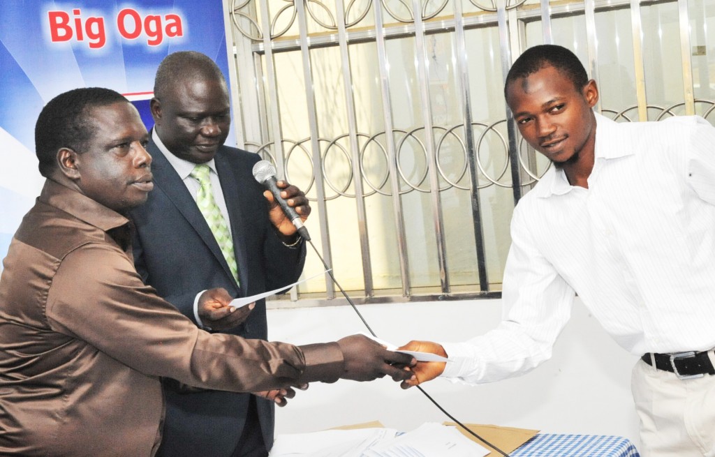 DSC_9862: L-R: DGM, Human Resources & Admin, Dangote Cement Ibese Plant, Mr. McDappa Ngo; DGM, External Relations, Dangote Cement Ibese, Mr. Joseph B. Alabi presenting scholarship award to Mr. Abubakar Amoo Akinlawon of Moshood Abiola Polytechnic, Abeokuta, Ogun State at Dangote Cement PLC presentation of scholarship award to Ibese Indigines 